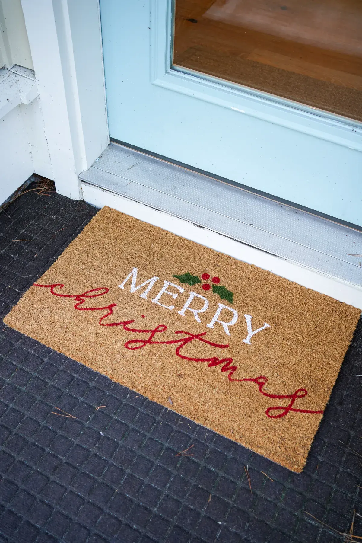 A Merry Christmas doormat at a front door