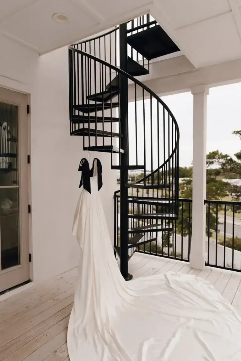 A wedding gown hanging in the light of a Grove bedroom